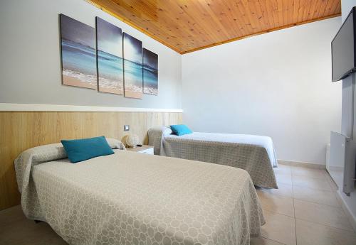 una camera con due letti e una tv di Apartamento con vistas en Pedras Negras a Pontevedra