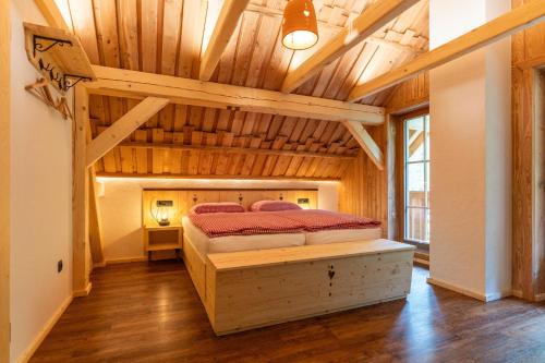 una camera da letto con un letto in una stanza con soffitti in legno di ALPIK Chalets - Bohinj a Bohinj