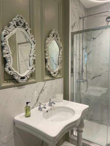 a white bathroom with a sink and a shower at Penarwyn House in Par