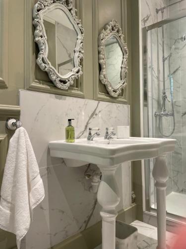 a bathroom with a sink and two mirrors at Penarwyn House in Par