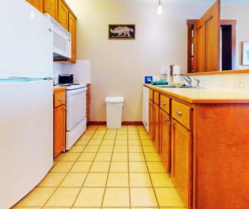 a kitchen with a white refrigerator and a tile floor at Allegheny228-230, Hot Tub,Pool,Ski In Out,Village in Snowshoe