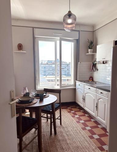 une petite cuisine avec une table et une fenêtre dans l'établissement Appartement - Triangle d'or - Vue Capucins, à Brest