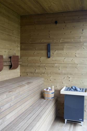a sauna with a wooden wall with a basket in it at Le Cattedrali Relais by Laqua Collection in Asti