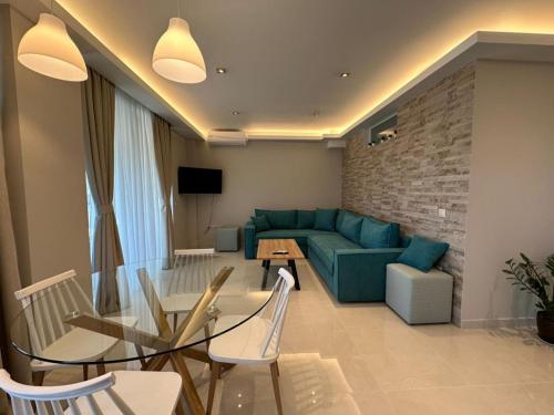 a living room with a couch and a table and chairs at Elpida Luxury Apartments Suites in Nydri