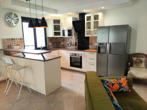 une cuisine avec un réfrigérateur en acier inoxydable et un comptoir dans l'établissement Le cosy de Noisy, à Noisy-le-Sec