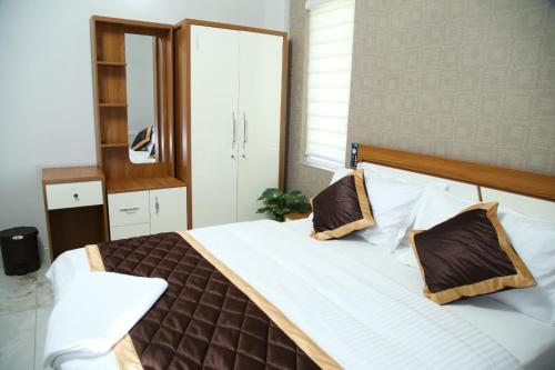 1 dormitorio con 1 cama grande y espejo en 88 homes kochi en Ernakulam