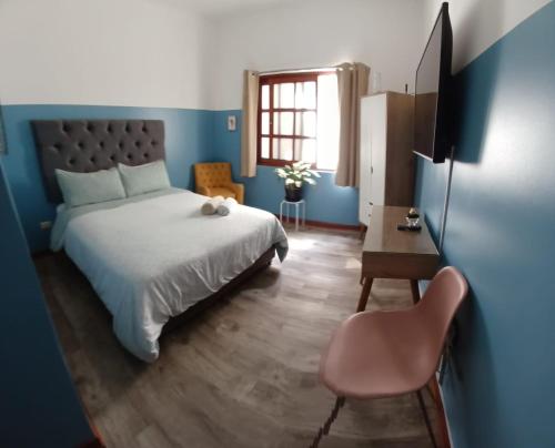 利馬的住宿－Miraflores Kennedy Park，一间卧室配有一张床、一张桌子和一把椅子
