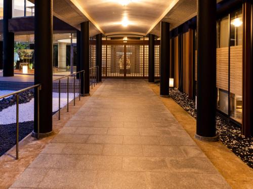 an empty hallway in a building with columns at APA Hotel & Resort Kaga Katayamazu Onsen Kasuikyo in Kaga