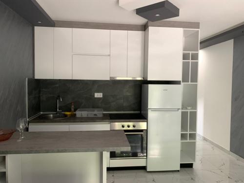 a kitchen with white cabinets and a counter top at Zlatna plaža in Bratunac