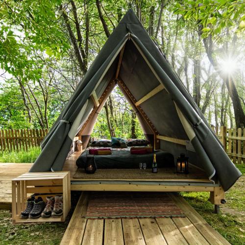 a bed in a teepee tent on a deck at Tenda Tipì Glamping Verde Mare by SMART-HOME in Genova