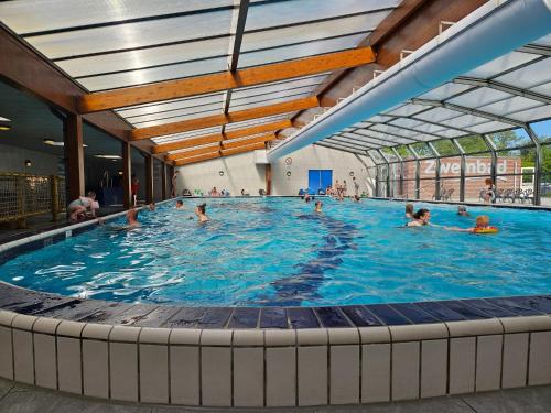 a large swimming pool with people in it at Madeliefje - Familie camping in Raalte in Raalte