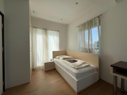 Schlafzimmer mit einem Bett und einem Fenster in der Unterkunft Villa Amela in Ilidža