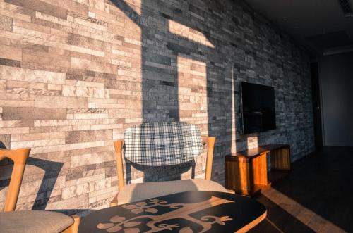 a room with a brick wall with a table and chairs at Something Easy Inn in Jiufen