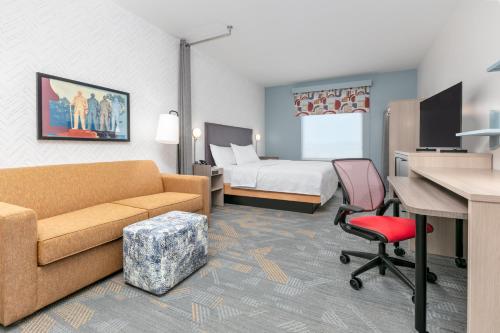 a hotel room with a couch and a bed and a desk at Home2 Suites By Hilton Huntsville, Tx in Huntsville