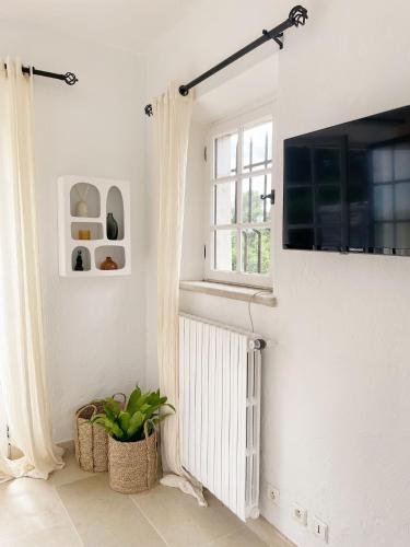 a white room with a radiator and a window at Le Mas Baïeta in Vence