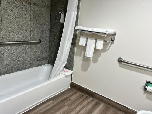 La salle de bains est pourvue d'une baignoire, d'une douche et de serviettes. dans l'établissement Econo Lodge Beaumont I-10 South, à Beaumont