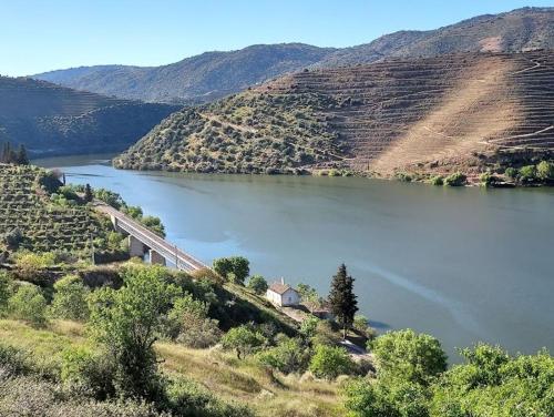 a view of a river with a bridge and a mountain at Casa da quelha- Arnozelo (Alto Douro Vinhateiro) in Arnozelo