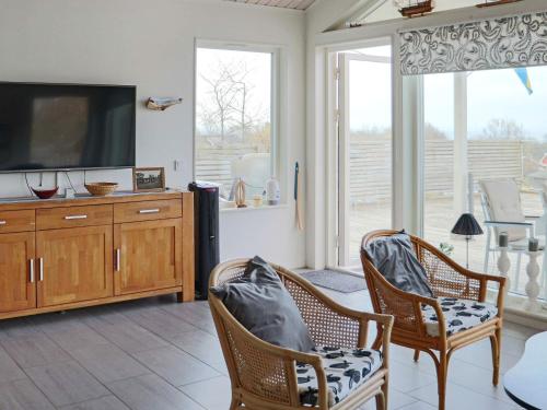 a living room with two chairs and a flat screen tv at 5 star holiday home in STENINGE in Steninge
