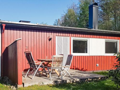 a table and chairs on a deck in front of a building at 4 star holiday home in Olofström-By Traum in Olofström