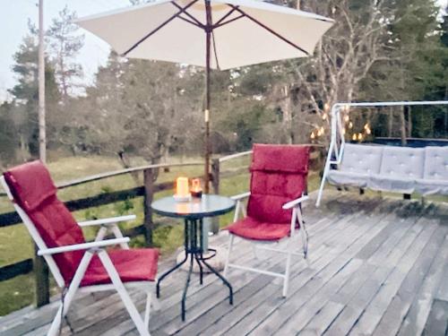 een tafel en twee stoelen en een paraplu op een terras bij 4 person holiday home in L RBRO in Lärbro