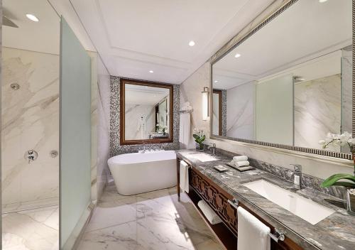 a bathroom with a tub and a large mirror at Hotel Luxury Villa Near Delhi IGI Airport in New Delhi