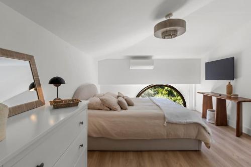 une chambre blanche avec un lit et un miroir dans l'établissement Adorable 2P avec Piscine Cannes, à Cannes