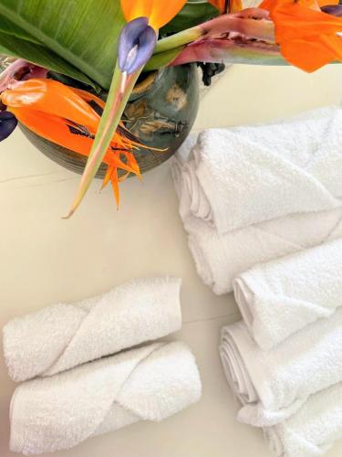 a vase filled with flowers next to a pile of towels at Loredana Affittacamere in Vittoria