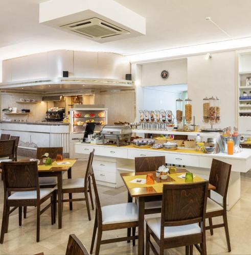 a kitchen with tables and chairs in a kitchen at Hotel Minerva in Siena