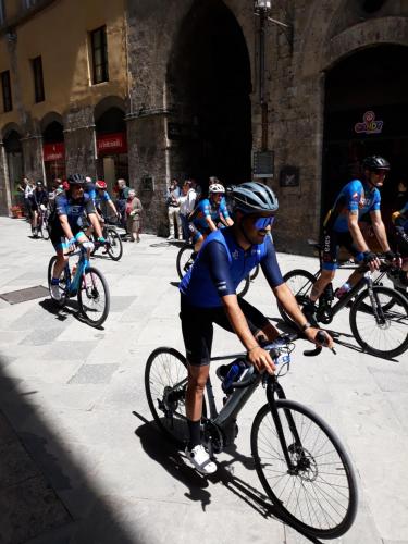 a group of people riding bikes down a street at Hotel Minerva in Siena