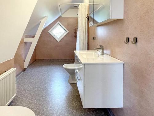 a bathroom with a toilet and a sink and a staircase at Holiday home HÖGSBY II in Högsby