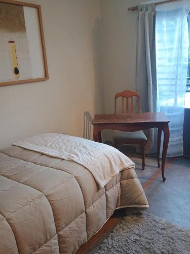1 dormitorio con mesa, silla y cama en Habitación tranquila e independiente al lado de la naturaleza y a las faldas del cerro San Cristóbal,, en Santiago