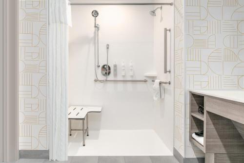 a bathroom with a bench and a shower at Home2 Suites By Hilton Huntsville, Tx in Huntsville