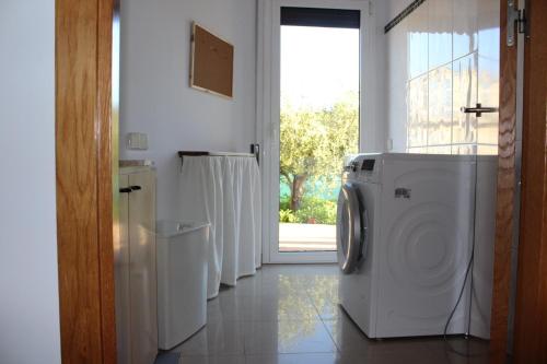 una lavanderia con lavatrice e finestra di el turó a Sant Boi de Lluçanès