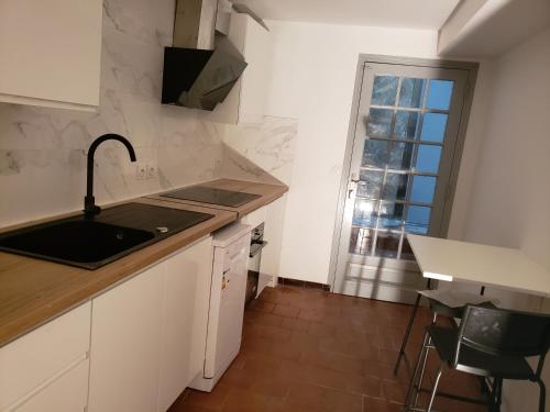 une cuisine avec un évier et un plan de travail dans l'établissement Chambres individuelles pour courtes et moyennes durées, à LʼIsle-Jourdain
