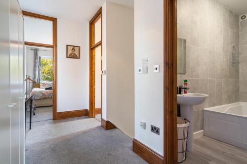 Modern 2 bedroom apartment in Mitcham, London في ميتشام: حمام مع حوض ومغسلة