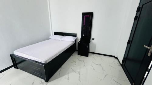 1 dormitorio pequeño con 1 cama con sábanas blancas en SHAKIN SHASHA BEACH HOUSE, en Jaffna