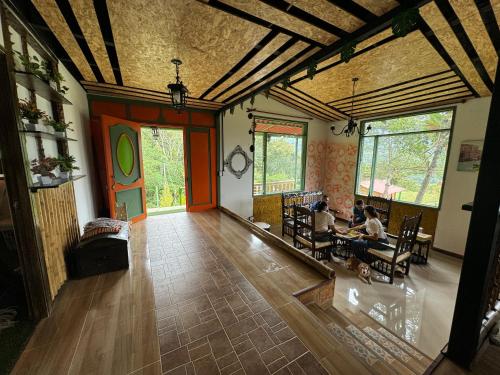 una sala de estar con 2 personas sentadas en una mesa en Eco hotel Birdland en Buga Valle, en La Habana