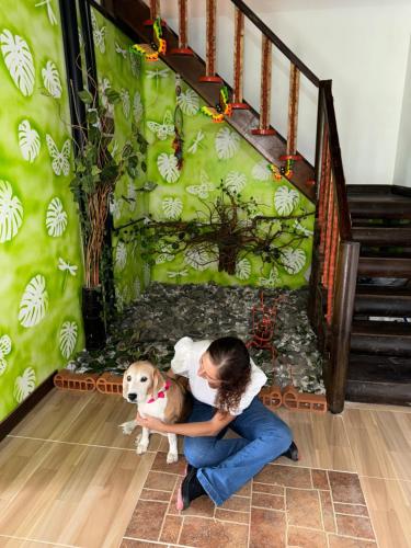 una chica sentada en el suelo con un perro en Eco hotel Birdland en Buga Valle, en La Habana