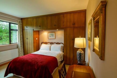 1 dormitorio con 1 cama con manta roja en An Dooneen, The Hurley Farm B&B, en Ballydavid