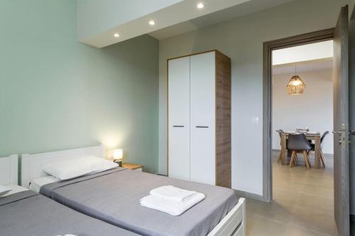 a bedroom with a bed and a dining room at ilios 3 bedroom apartment with sea view in town in Skala Kefalonias