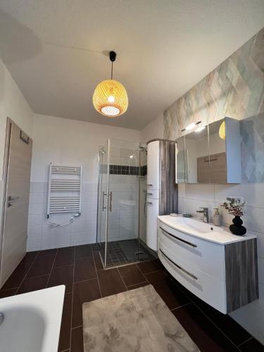 a bathroom with a tub and a sink and a shower at Ferienwohnung Maasch in Vierraden