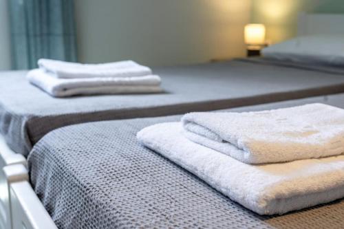 two beds with white towels on top of them at ilios 3 bedroom apartment with sea view in town in Skala Kefalonias