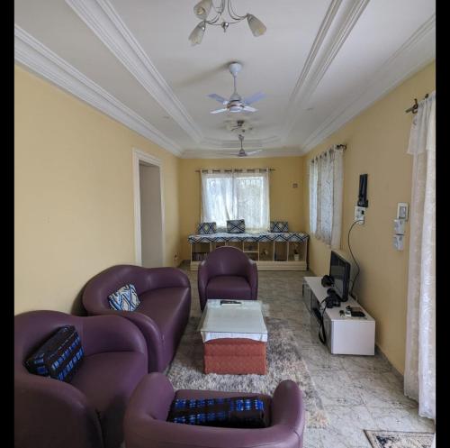 a living room with two couches and a tv at Mount Pleasant in Brufut