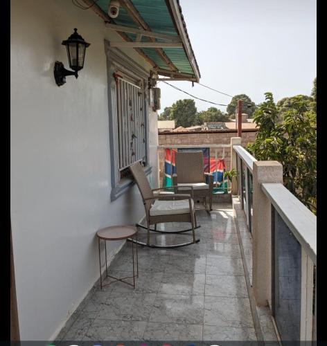 a balcony of a house with chairs and a table at Mount Pleasant in Brufut