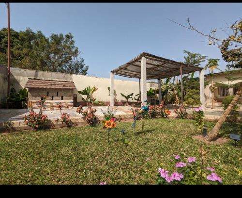 a garden with a pavilion and flowers in the grass at Mount Pleasant in Brufut