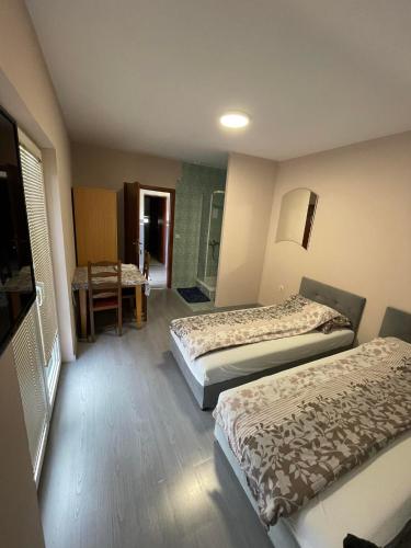 une chambre d'hôtel avec deux lits et une chaise dans l'établissement Pansion Lapam, à Visoko