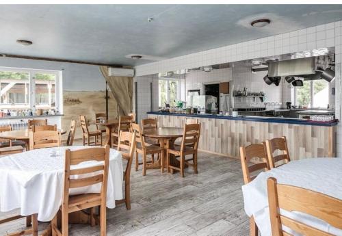 a restaurant with tables and chairs and a kitchen at Davids Hotell in Alvesta