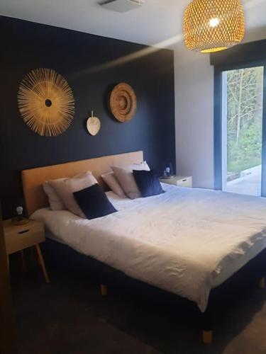 une chambre avec un grand lit blanc avec des oreillers bleus dans l'établissement Jolie villa avec piscine, à Palaja