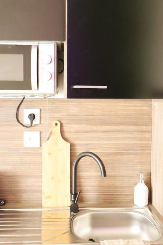 un comptoir de cuisine avec un évier et un micro-ondes dans l'établissement Loveroom Japon avec balnéothérapie, à Toulon