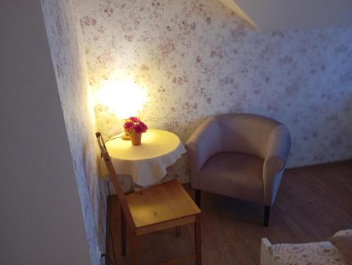 een kleine kamer met een tafel, een stoel en een lamp bij Pokoje gościnne u Aleksandry in Hel